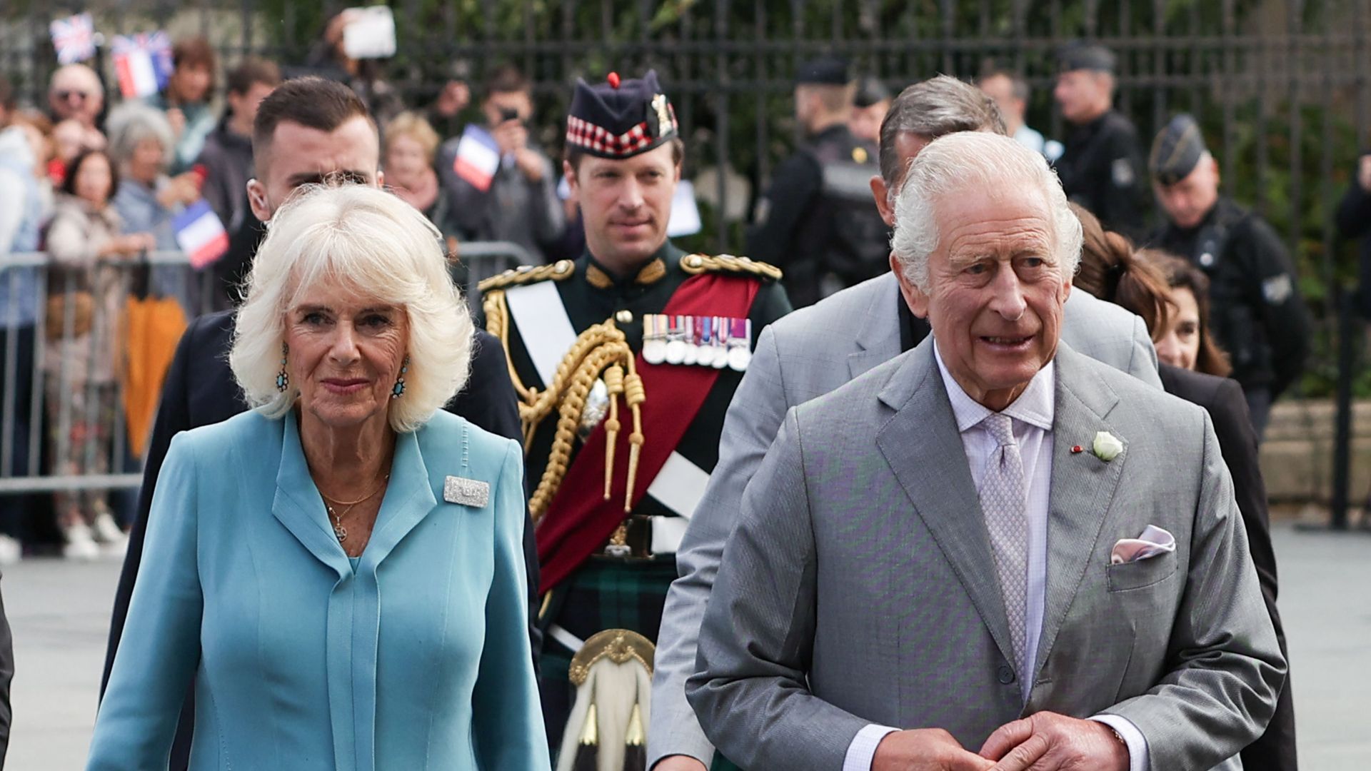 Lt Col Johnny Thompson is pictured walking behind Charles and Camilla in France