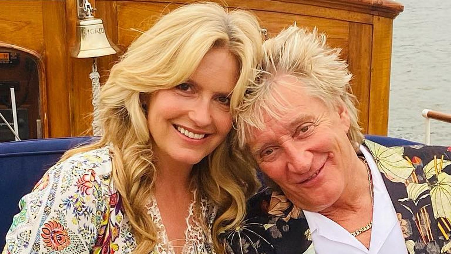 Penny Lancaster wearing floral dress posing next to husband Rod Stewart in floral suit in Venice