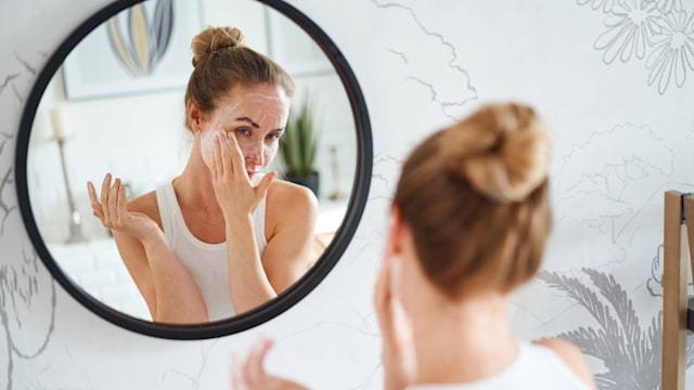 Woman cleaning face with cosmetic product