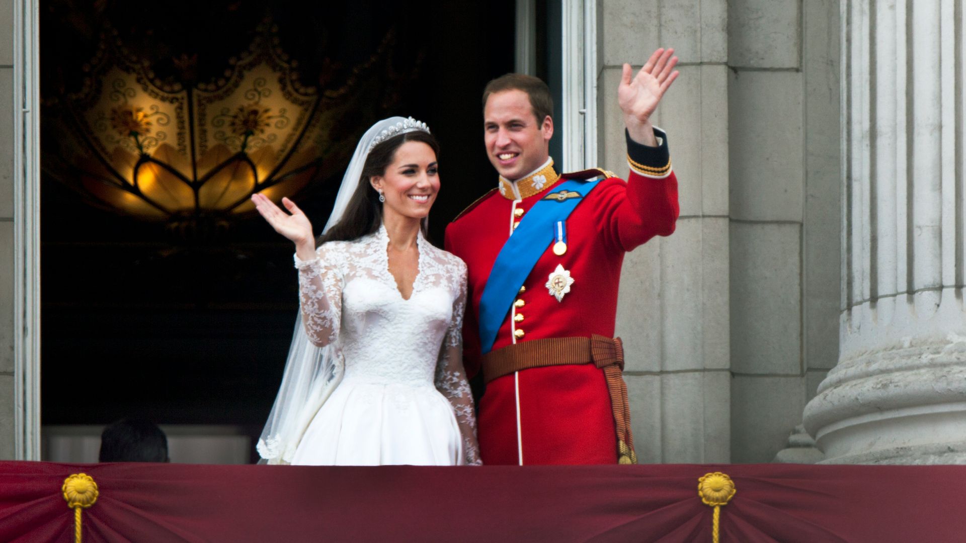 Prince William and Kate Middleton in their wedding outfits waving from Buckingham Palace's balcony