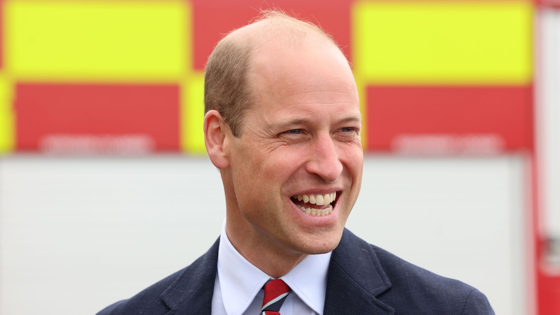 Prince William is seen laughing after a simulated fire response exercise during an official visit at RAF Valley