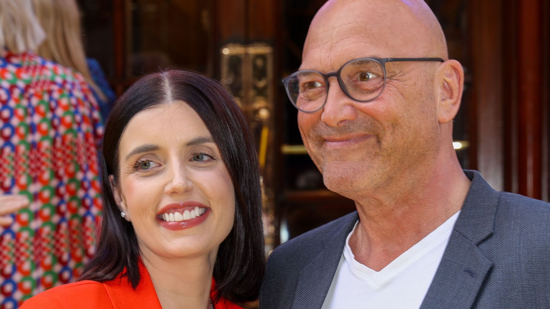 Gregg Wallace in a grey suit with Anne-Marie in a red jacket