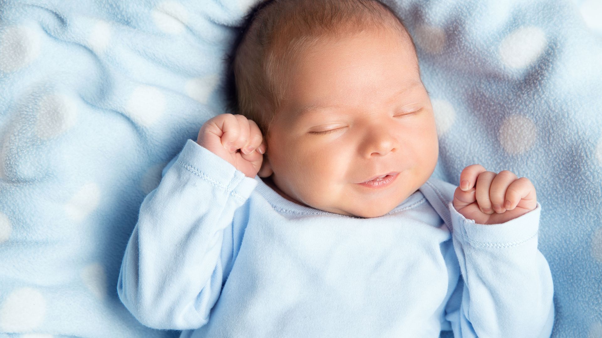 A baby smiling in his sleep