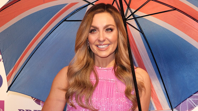 Amy Dowden in pink dress holding an umbrella