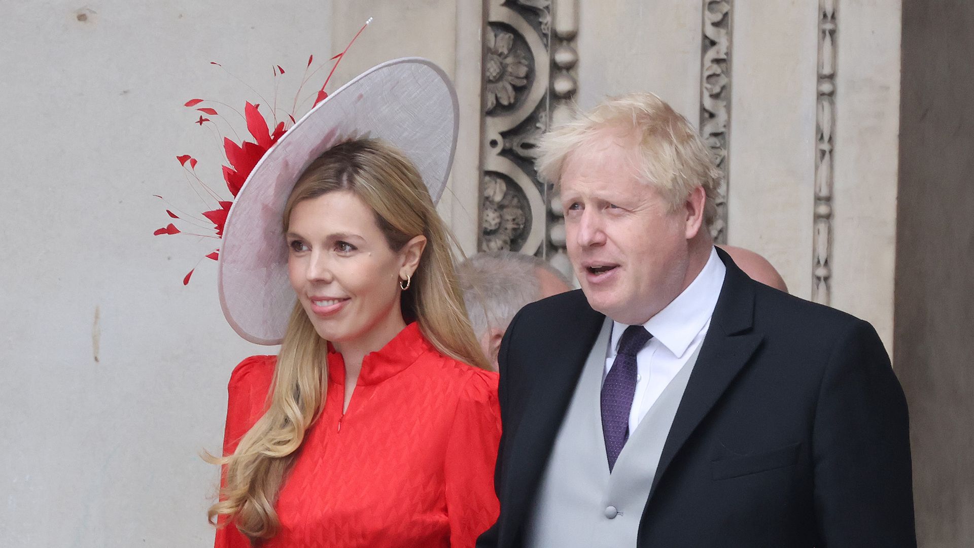 Boris Johnson in a suit and Carrie in red dress leaving St Paul's Cathedral