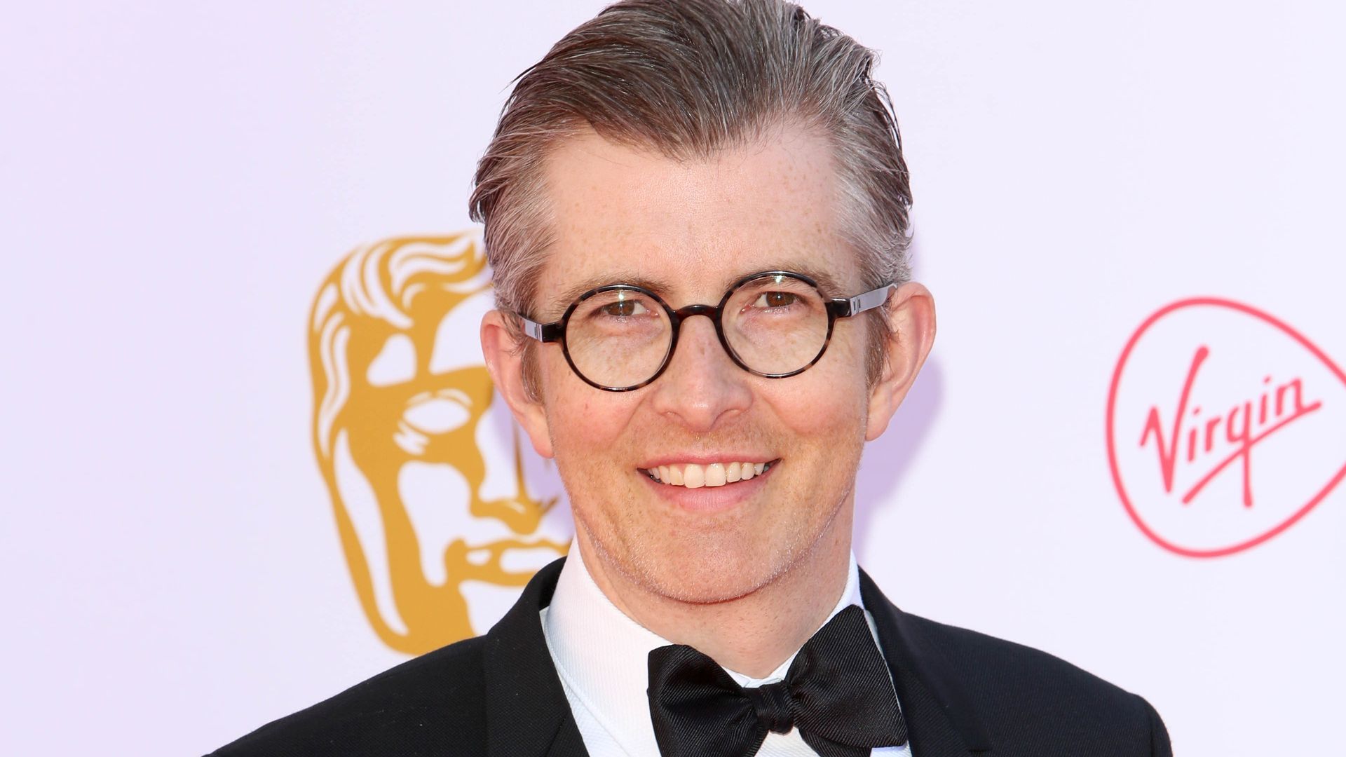 Gareth Malone stands in a suit on red carpet at the BAFTAs