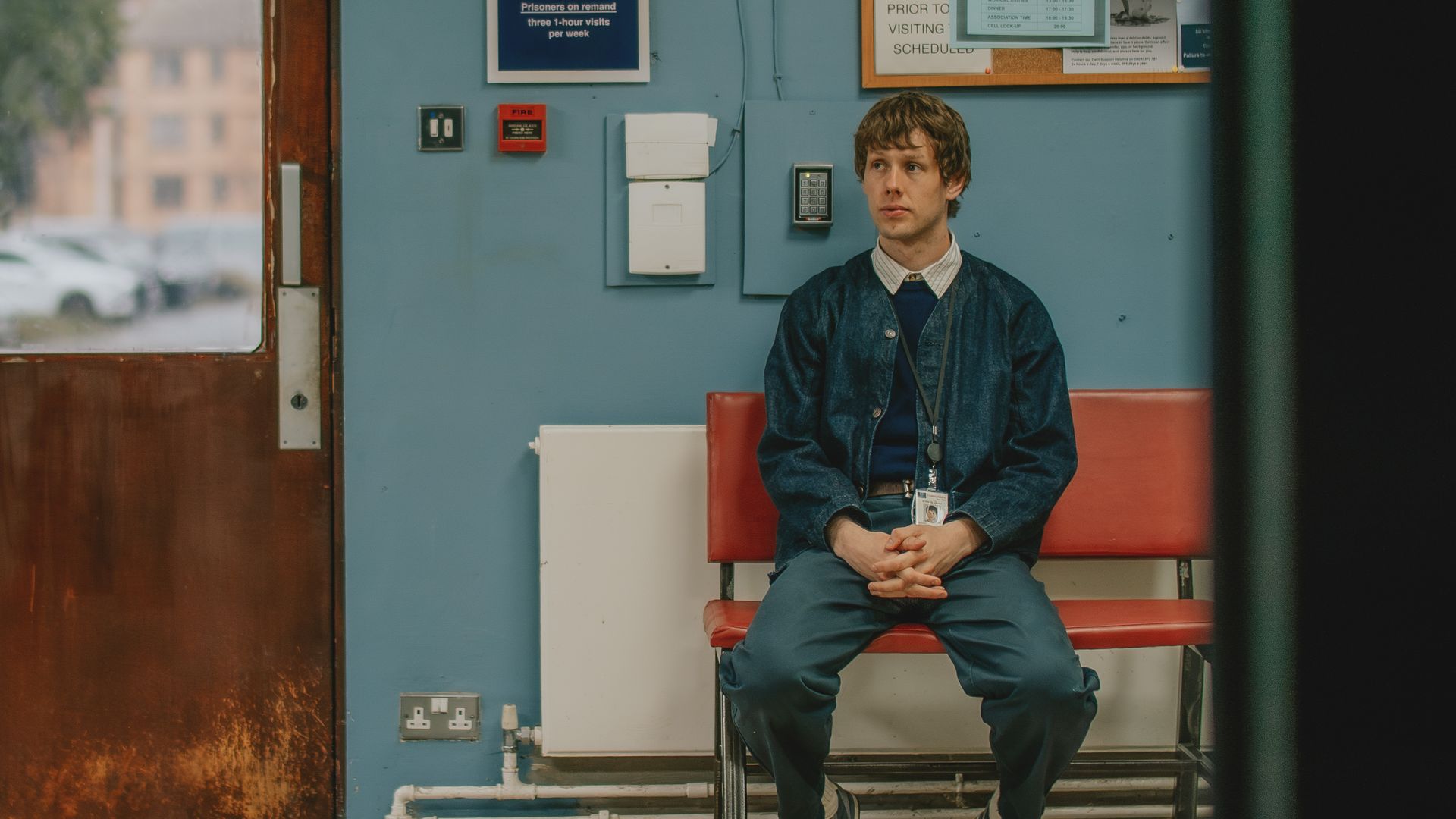 Josh Finan sitting inside a prison in a scene from Waiting for the Out