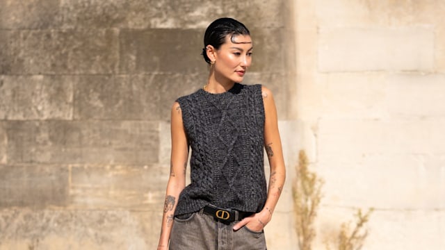 Amalie Gassmann wears a grey knitted vest, grey jeans, Dior belt and Dior printed bag, outside Dior, during the Womenswear Spring/Summer 2024 as part of  Paris Fashion Week on September 26, 2023 in Paris, France. 