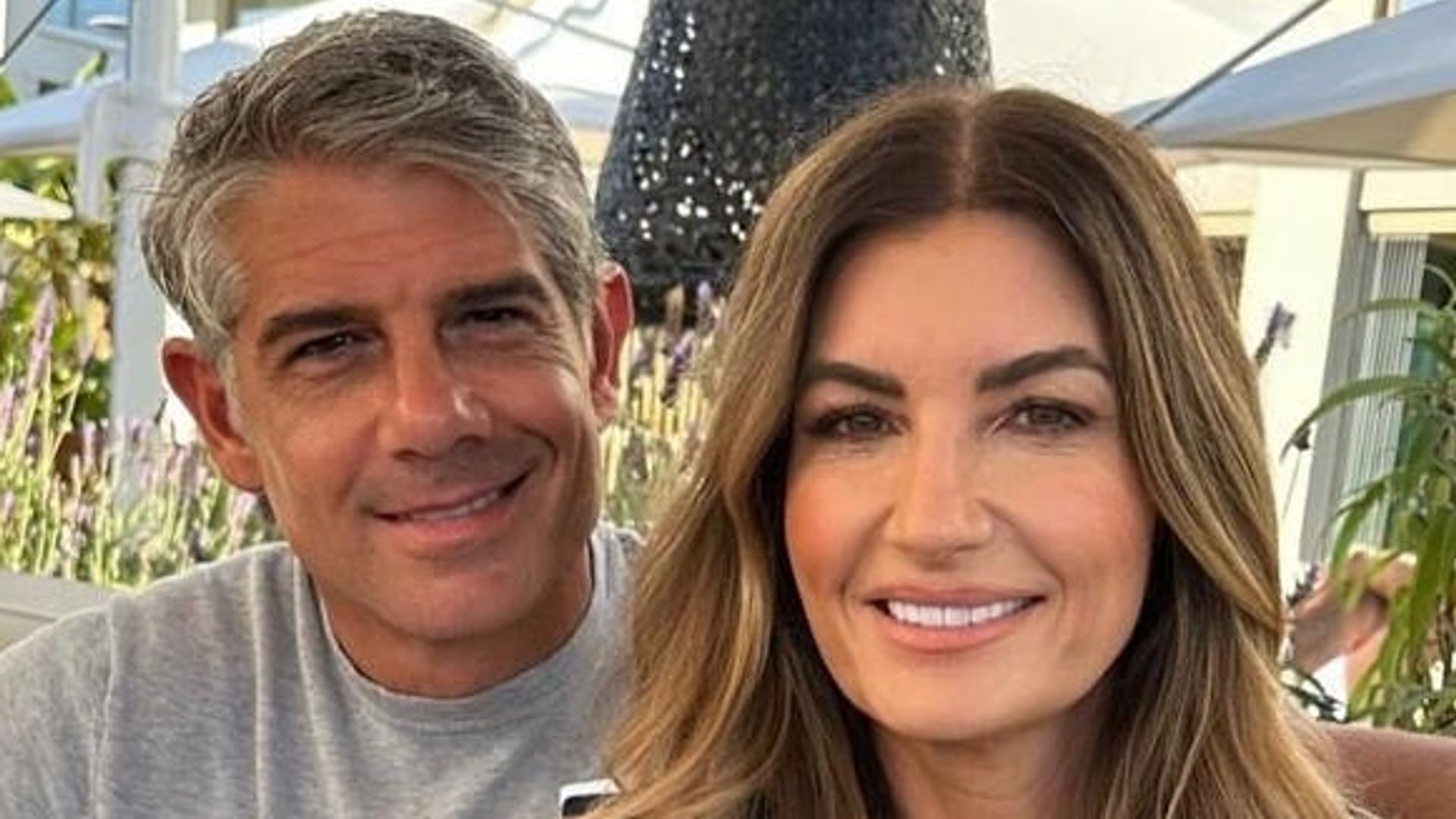 Karren Brady in striped tee with husband in grey top