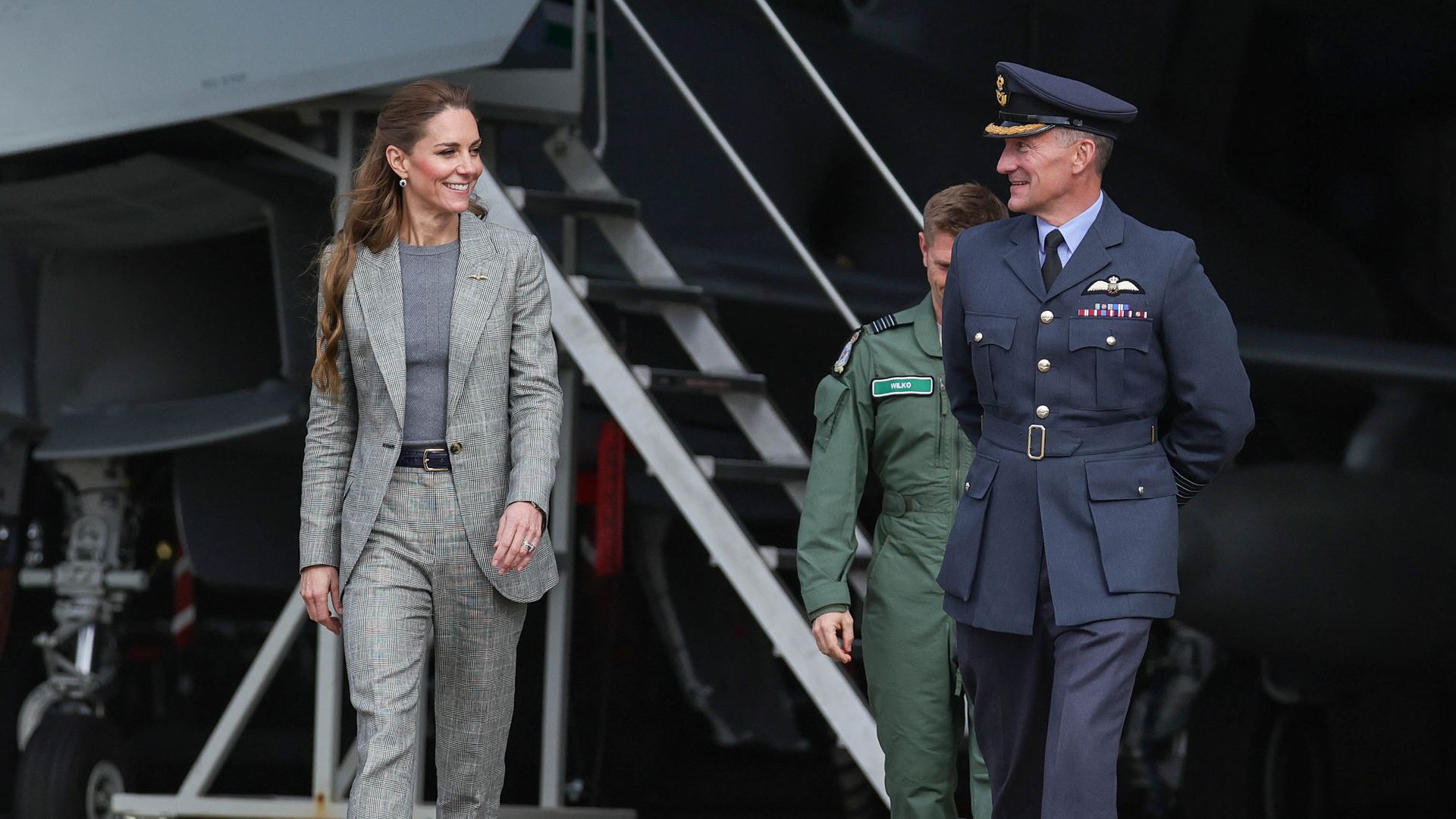 Kate Middleton in grey suit walking with officer