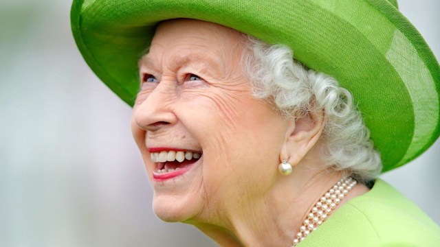 the queen smiling green hat