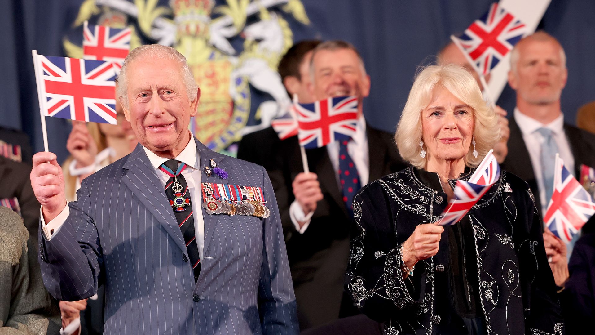 Charles and Camilla waving flags at concert