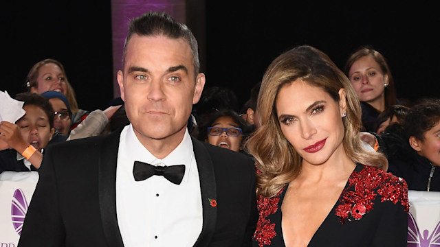 Robbie Williams in tuxedo and Ayda Field in black dress