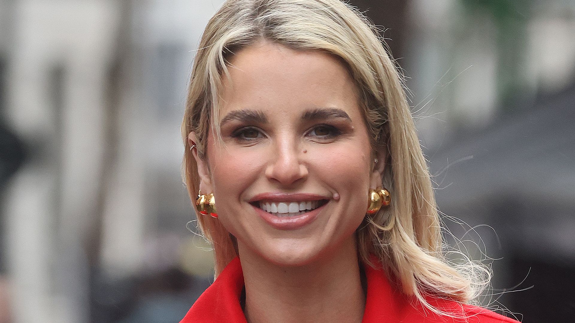 Vogue Williams in a red outfit outside