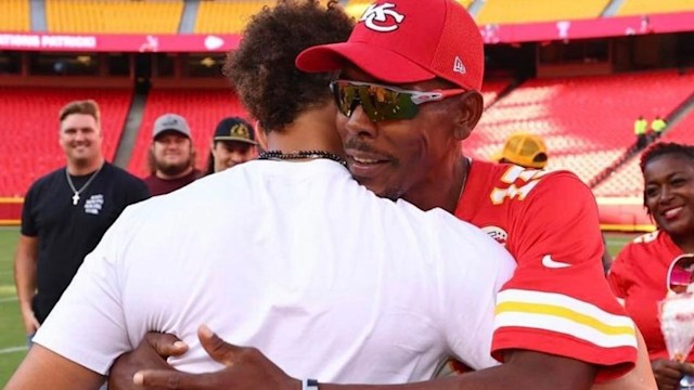 Pat Mahomes hugging his son Patrick on a football pitch