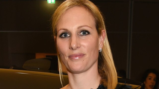 Zara Tindall in a black outfit next to a car