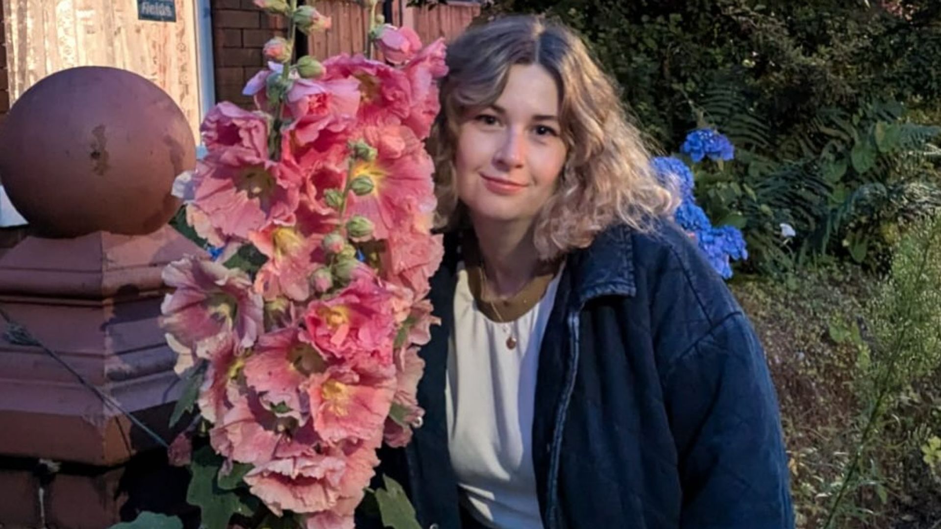 woman posing next to a giant flower