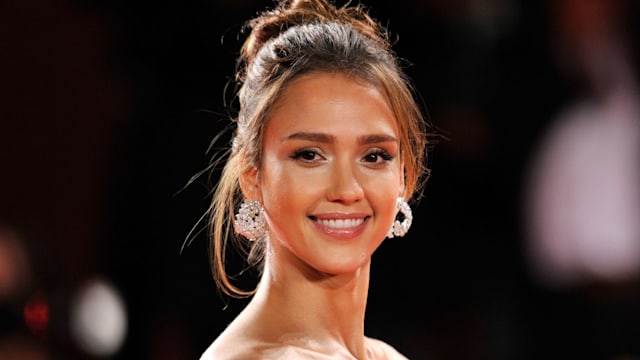 Actress Jessica Alba in a strapless dress with her hair in a bun and silver earrings