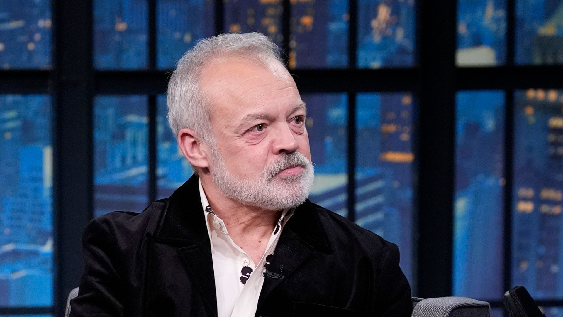 man on talk show with nighttime backdrop