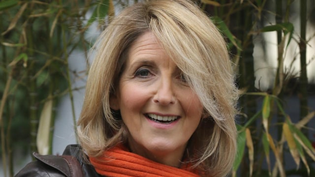 kaye adams with orange scarf and coat