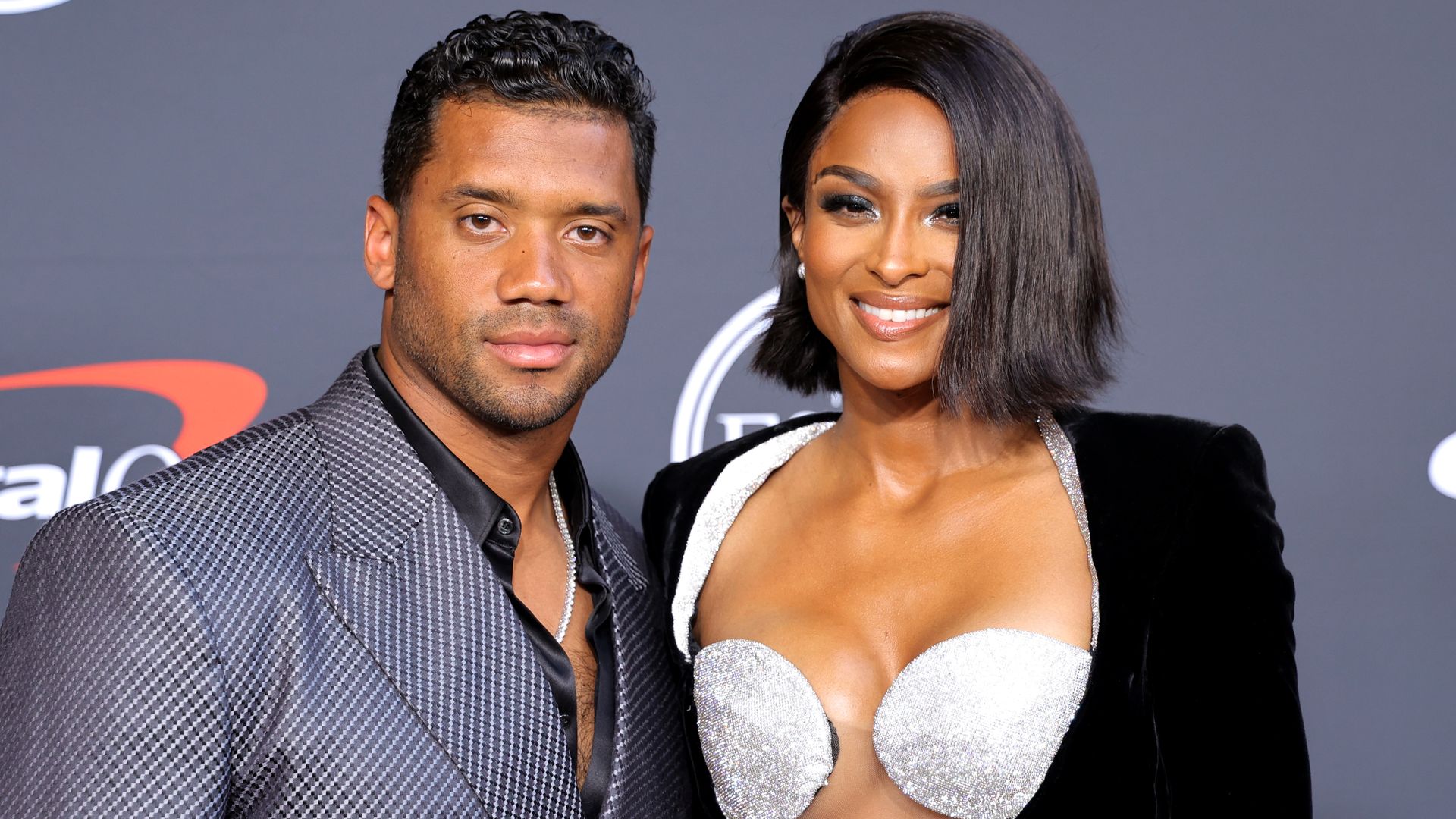 Ciara and Russell smiling at a red carpet event