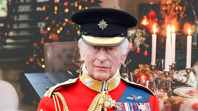 King Charles in red with christmas dinner backdrop