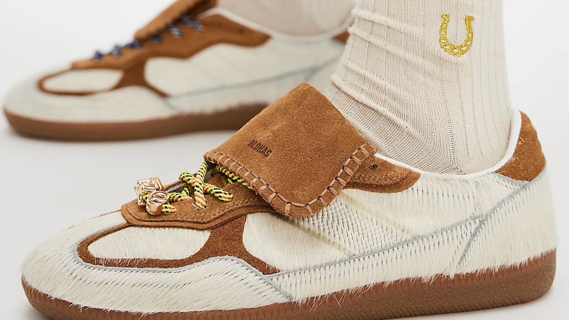 A close up of a model wearing a cream pair of Alohas Tb.490 Club Sneakers and a set of ribbed socks 
