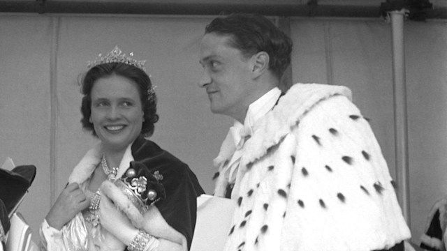 This black-and-white photo captures Lord and Lady Woolton alongside the Marquess and Marchioness of Anglesey at Queen Elizabeth II’s Coronation. The group is elegantly dressed in ceremonial robes trimmed with fur and adorned with crowns. The Marchioness of Anglesey smiles warmly, wearing a tiara and jewels. The formal atmosphere reflects the grandeur of the historic event at Westminster Abbey.