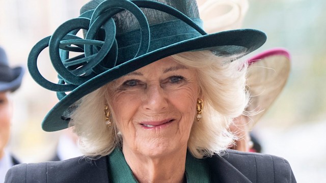 Queen Camilla wearing green dress and hat