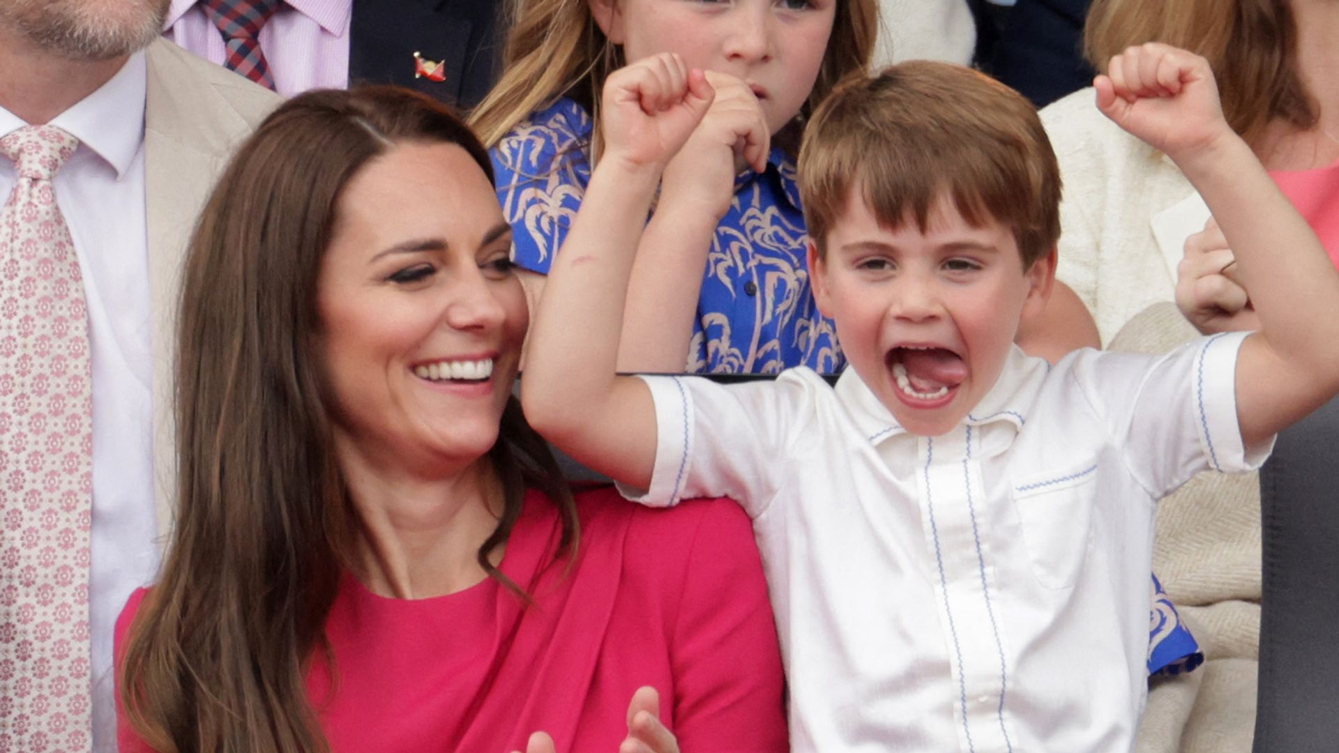 Princess Kate clapping beside her son Prince Louis, who has his arms in the air