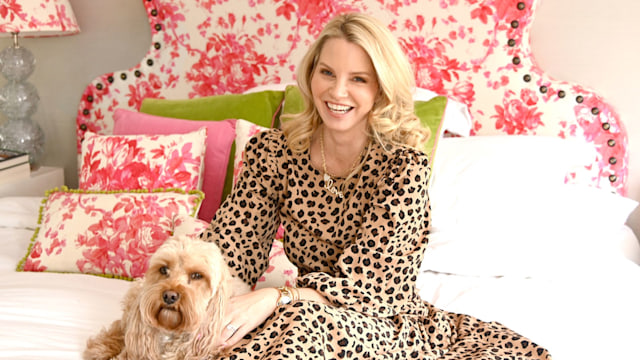 Woman sitting on a bed in a leopard print dress