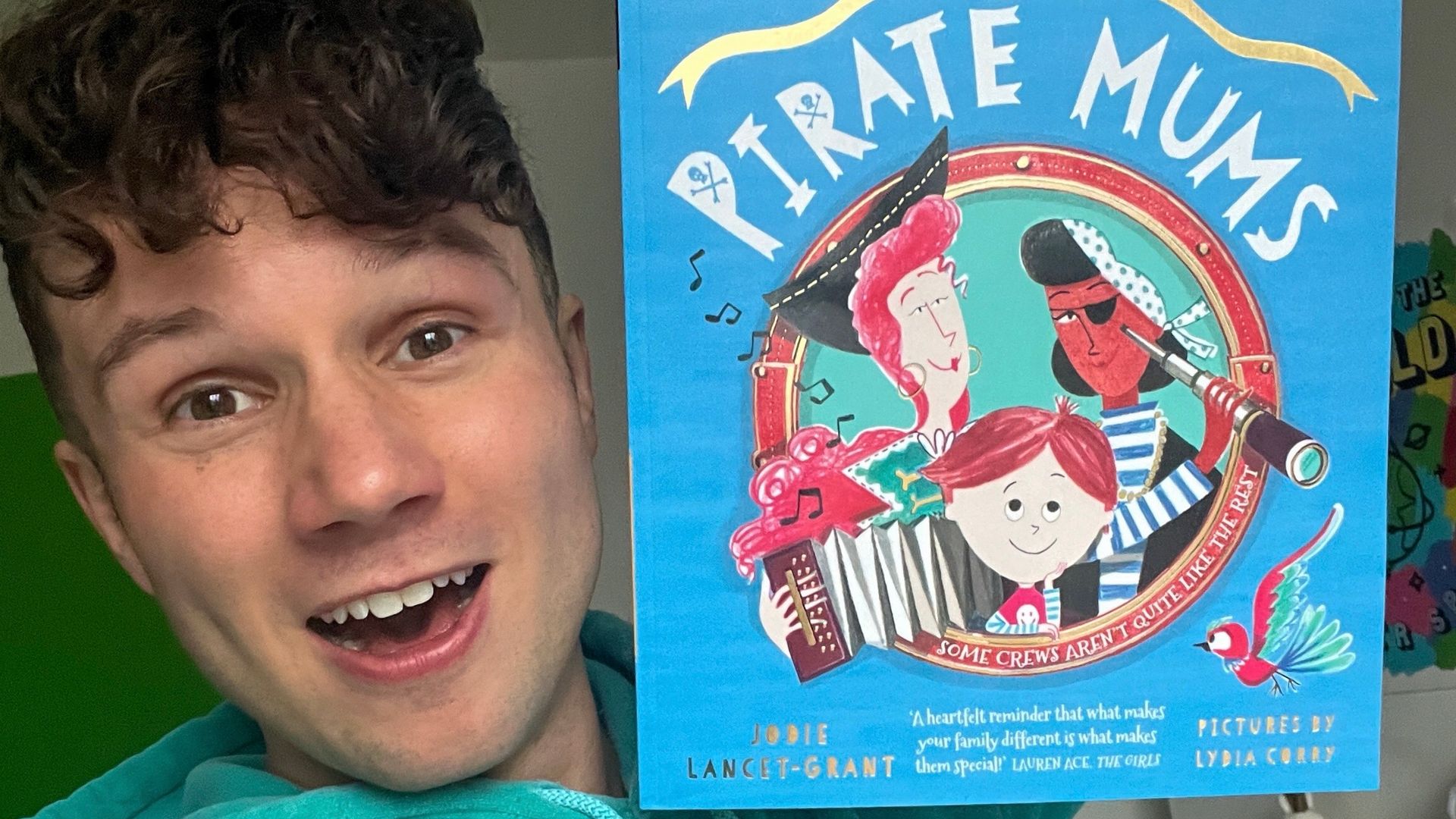 Olly Pike holding up a copy of The Pirate Mums