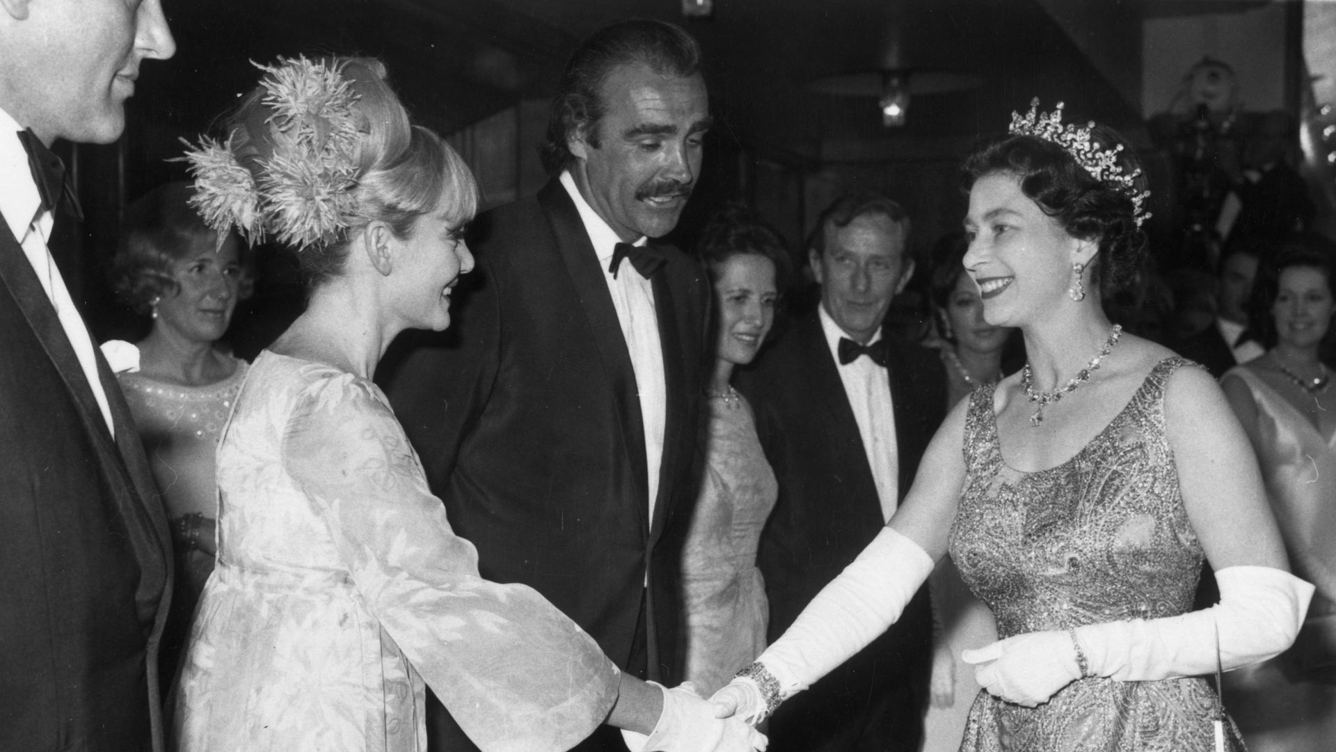 queen shaking hands with diane cilento at premiere