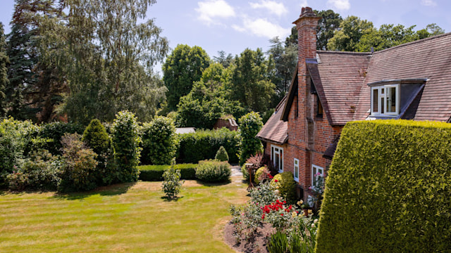 Careys Manor exterior view of lawn with manicured hedges and hotel