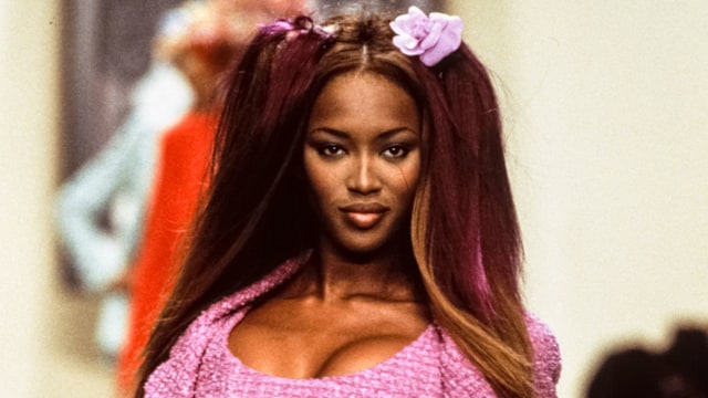 Naomi Campbell wearing a pink mini dress and matching jacket with a black and white chain belt in Chanel's Ready to Wear Spring/Summer 1993-1994 show