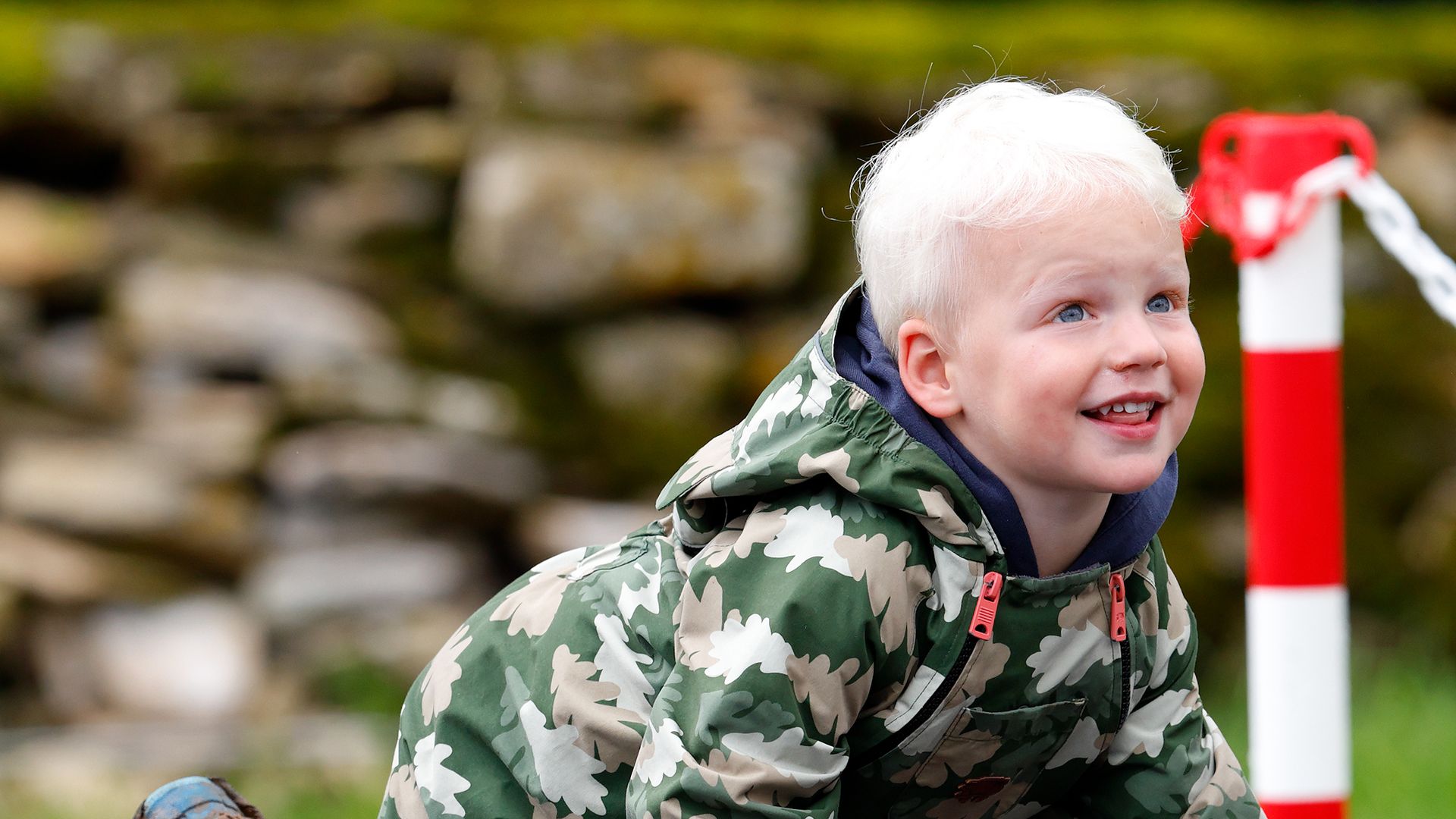 little boy on trampoline in puddlesuit 