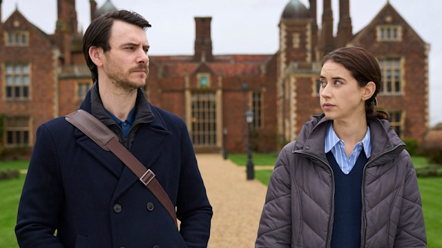 Man and woman looking at each other standing in front of country mansion