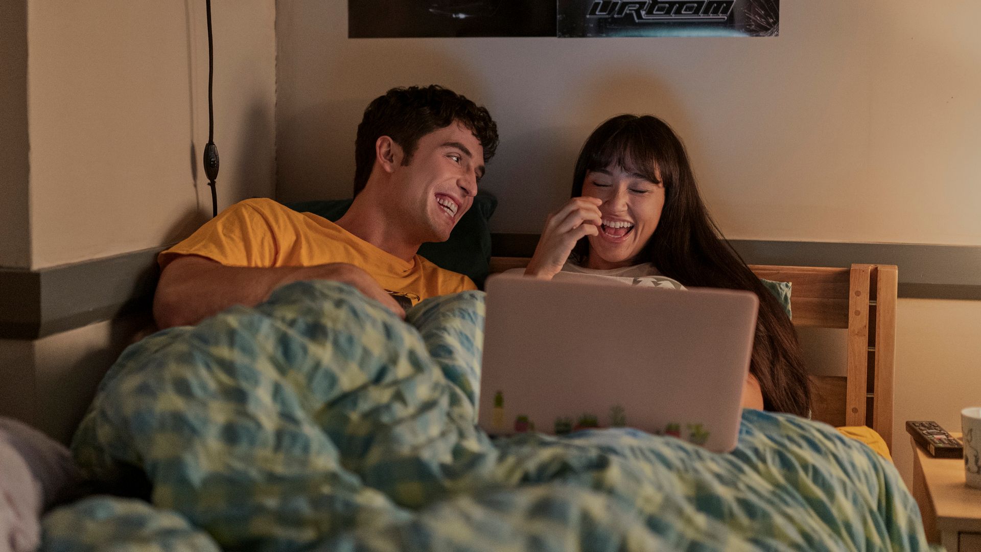 man and woman laughing in bed