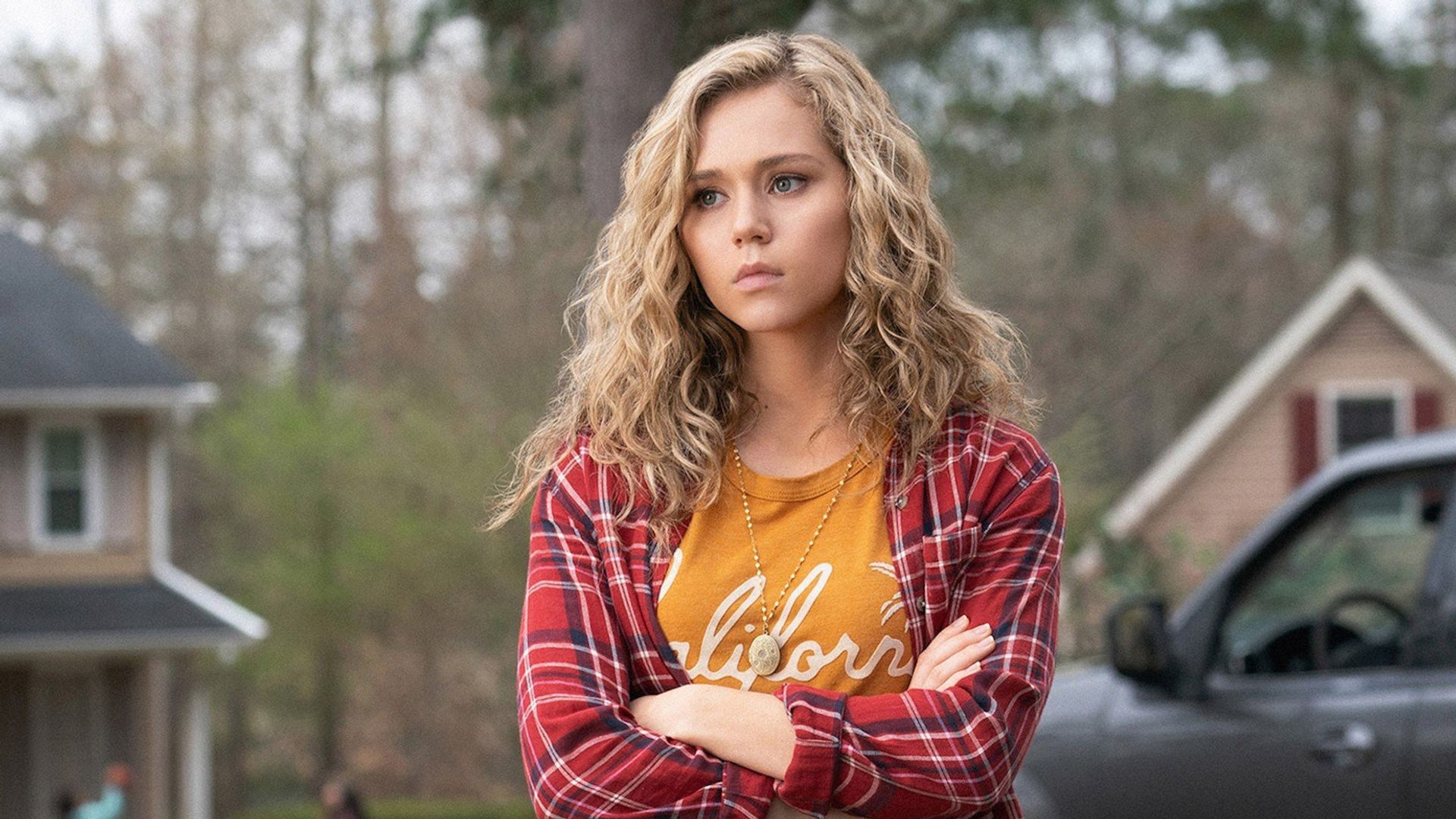 young woman folded arms standing in street