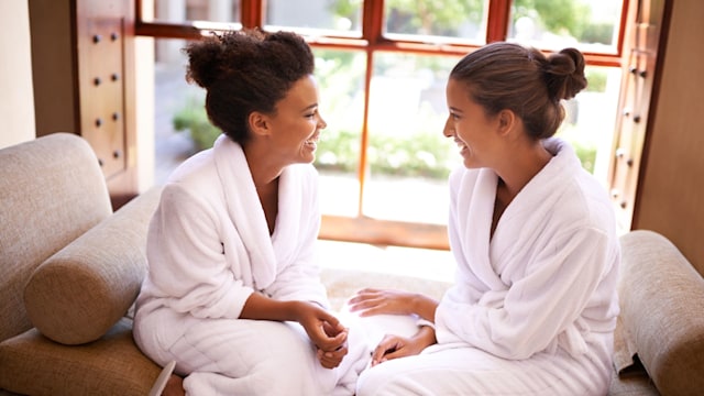 Two women smiling in robes