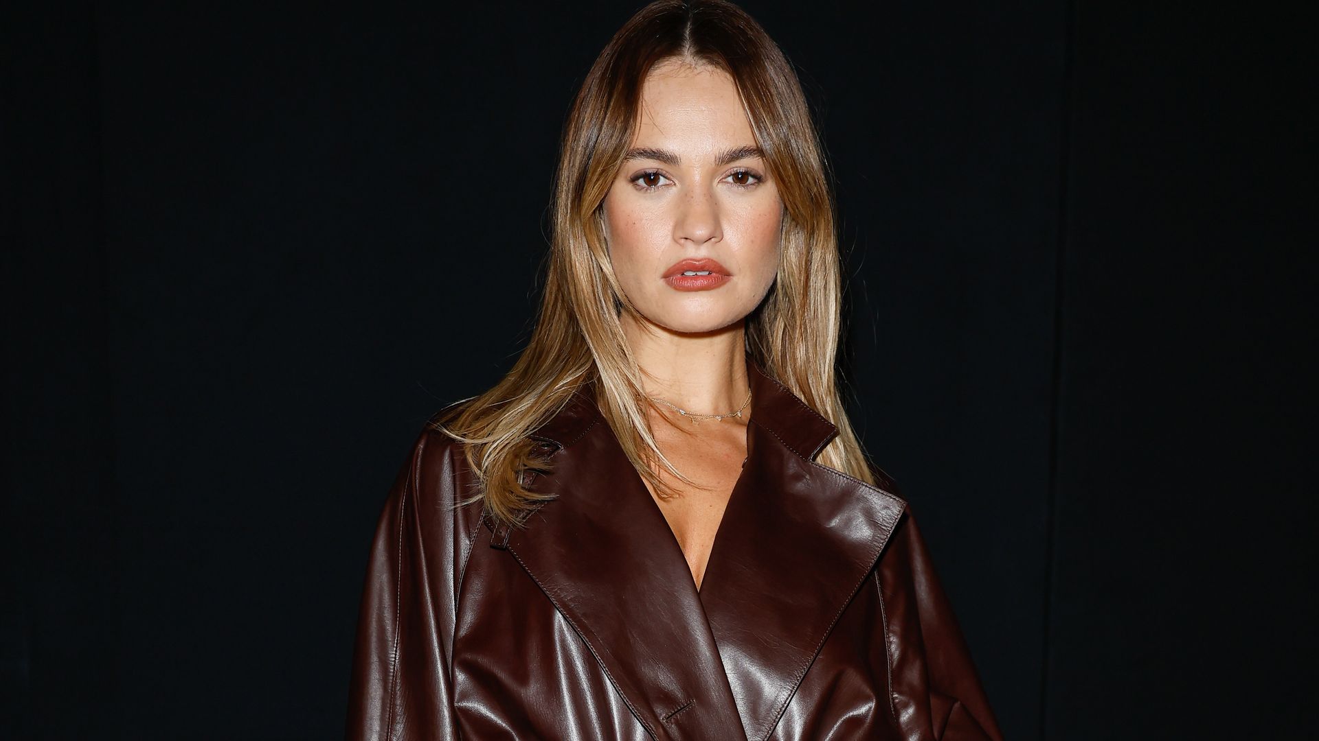 lily james in brown patent coat