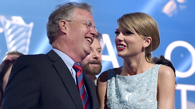 Taylor standing laughing with her dad Scott at an event