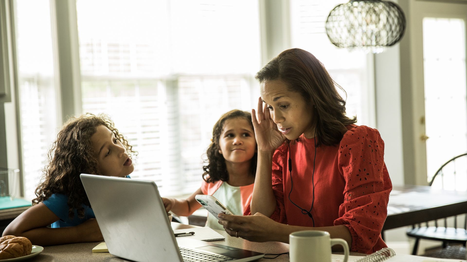 Mother working from home with children in background