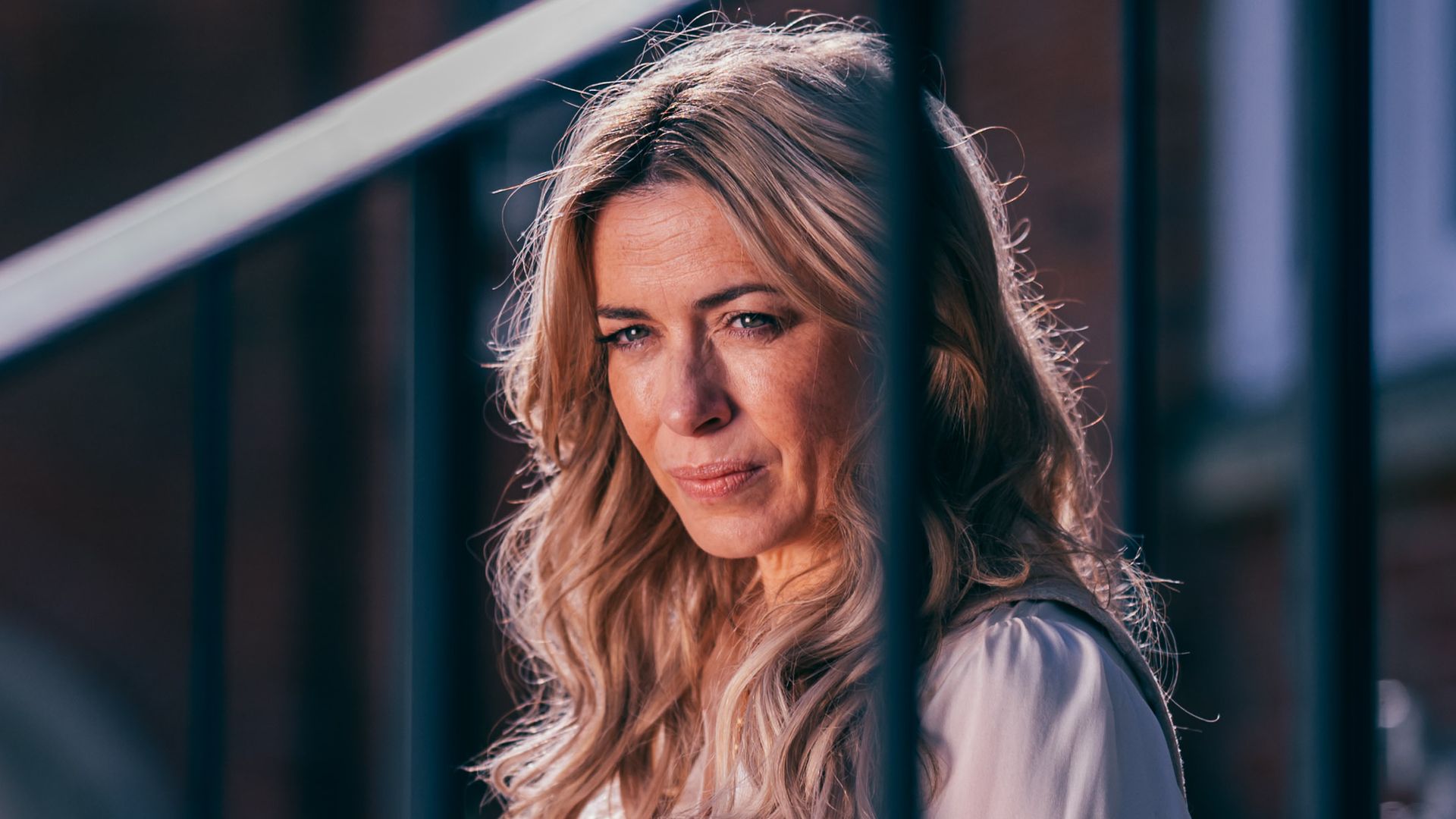 Eve Myles as Fran Sharp sitting on stairs outside