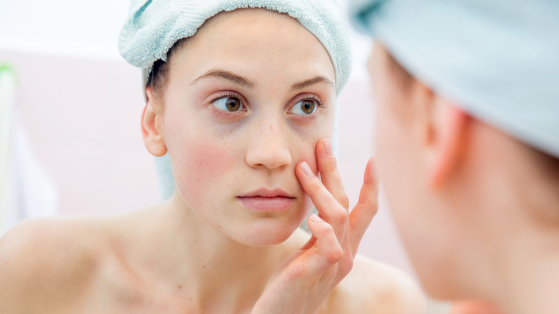 Young woman portrait in the mirror of her bathroom after taking shower