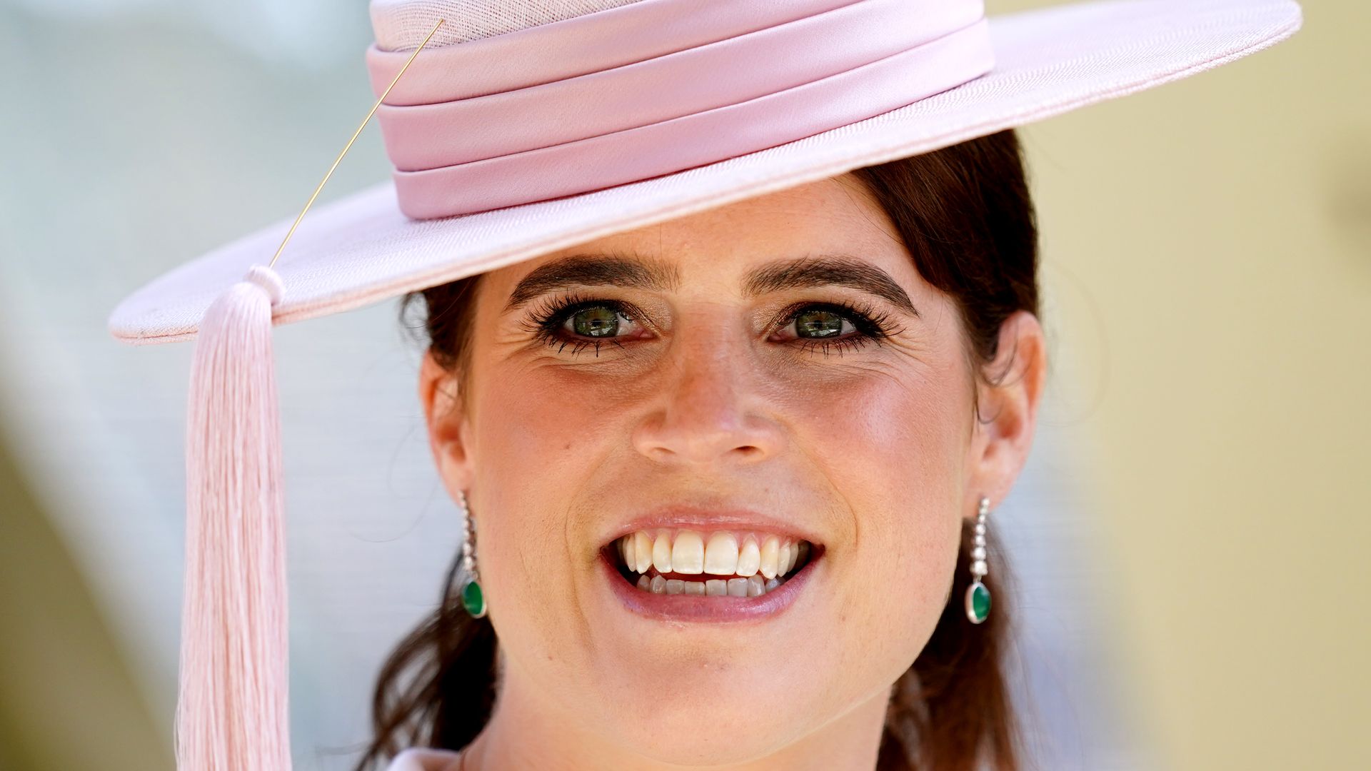 Princess Eugenie smiling in pale pink hat