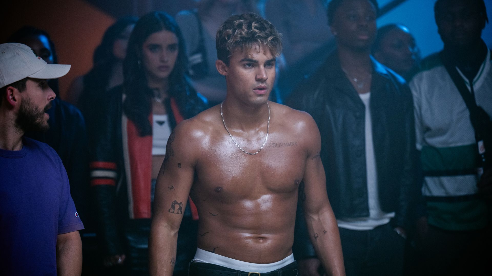 young man topless surrounded by people