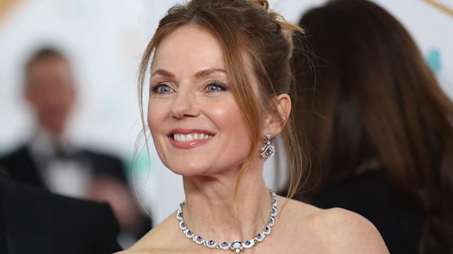 Geri Horner smiling in a strapless white dress with her hair up