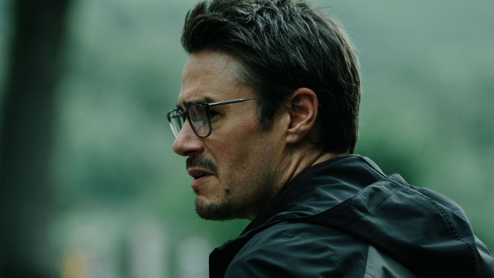 close-up of man in glasses in forest