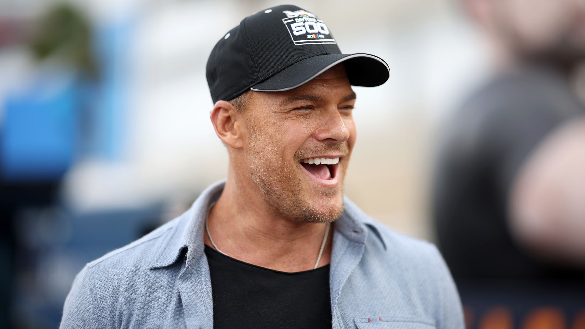 Alan Ritchson is all smiles wearing baseball cap